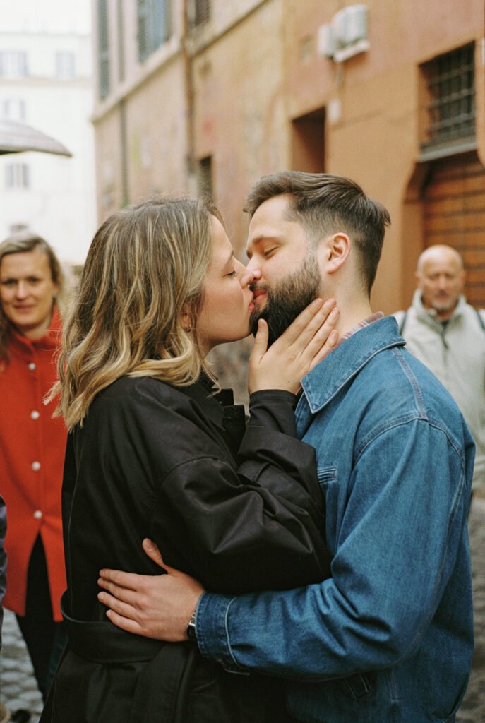 A young couple kissing each other in Trastevere, Rome.