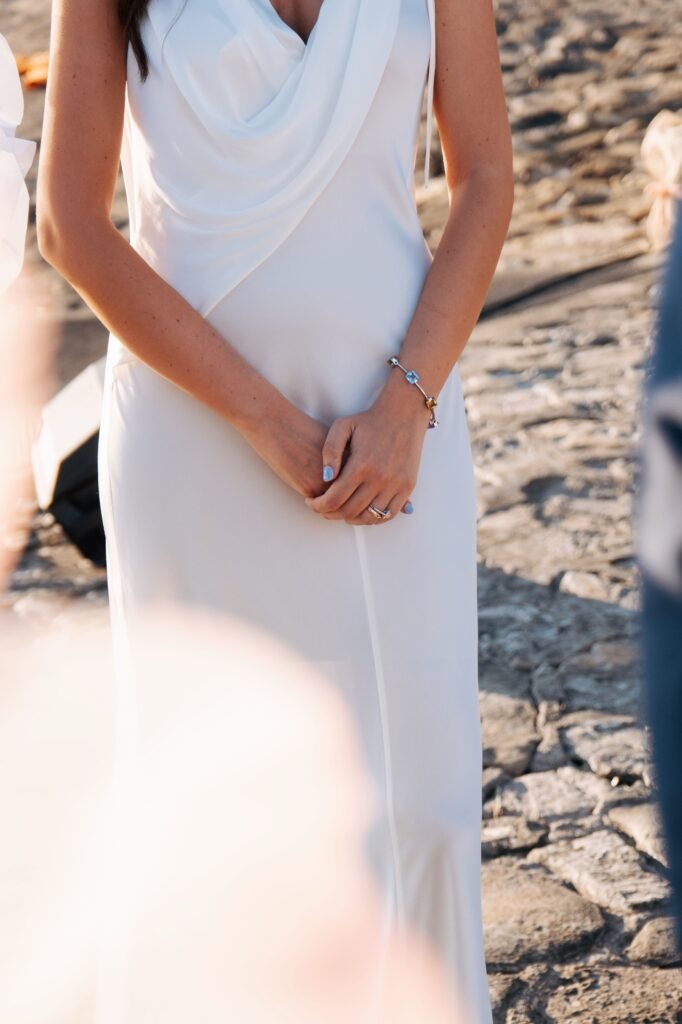 Close-up of bride’s hands and white wedding dress at Villa La Saracena.