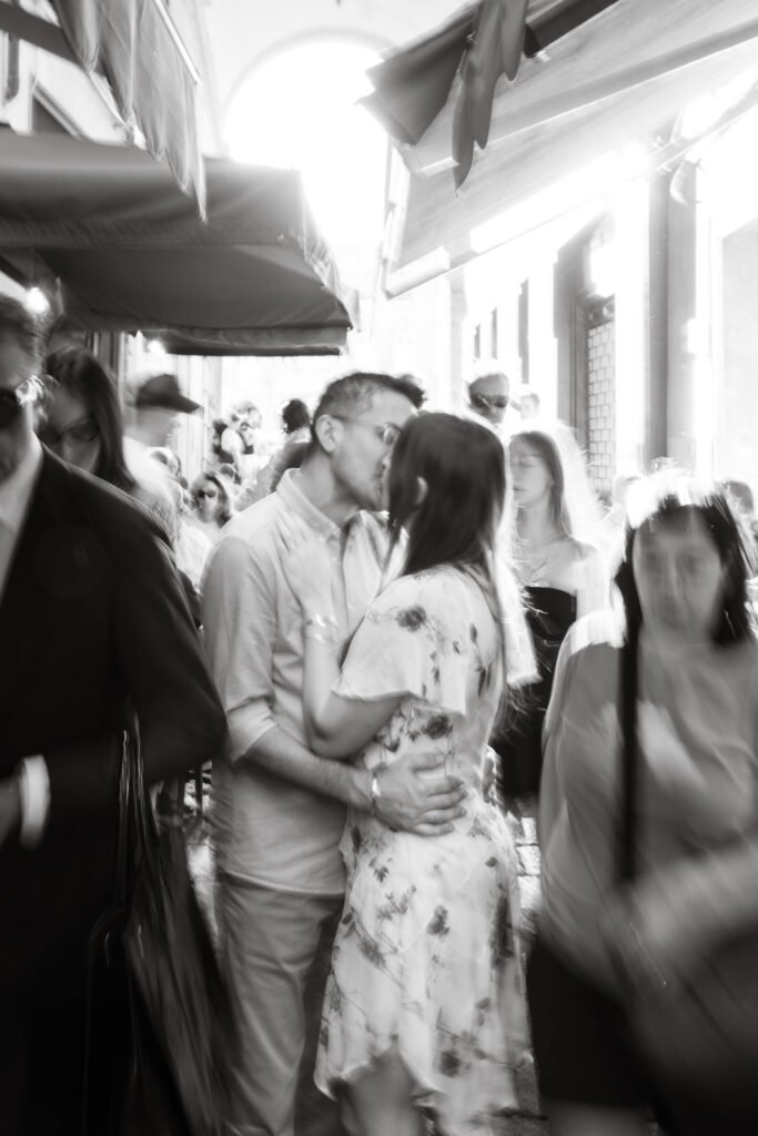 Coppia che si bacia nelle strade affollate di Bologna durante un servizio fotografico.