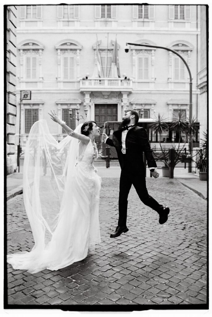 Film Wedding Photographer in Italy 2 Bride and groom jumping together in celebration during their Rome elopement, photographed on film.