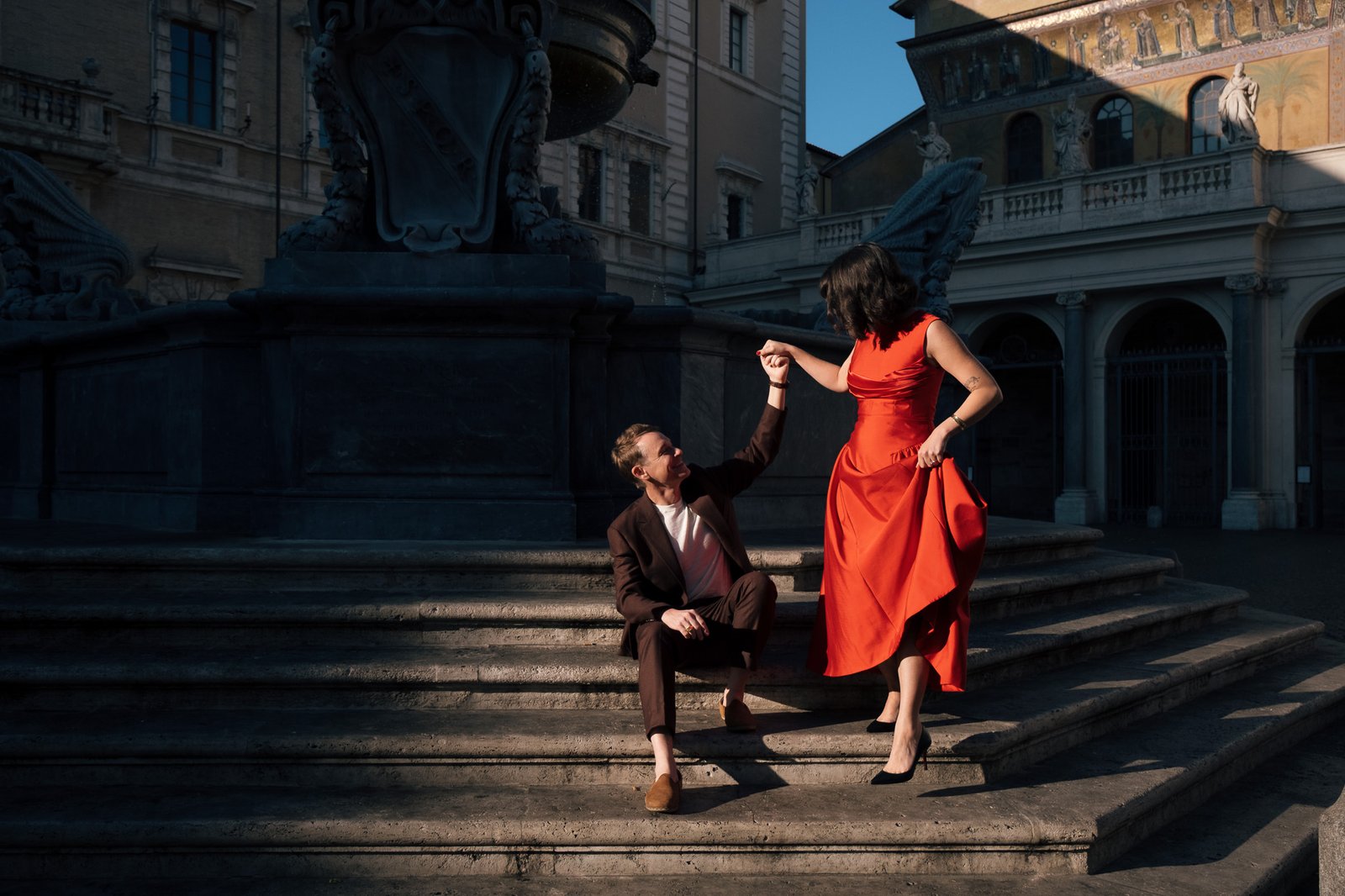 Coppia sui gradini in marmo di Trastevere durante un servizio fotografico di rinnovo promesse matrimoniali a Roma, Italia.