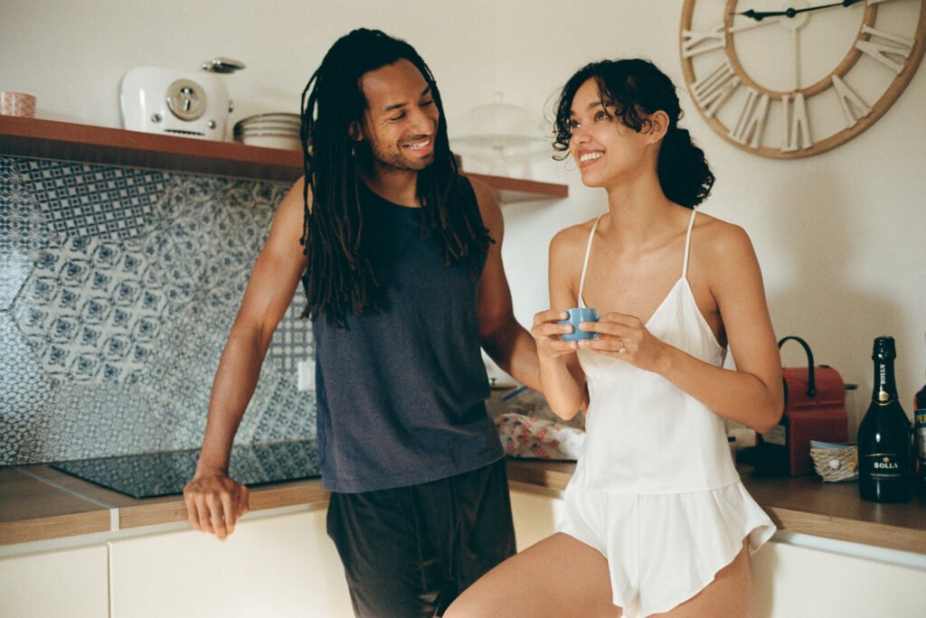Couple sharing coffee in kitchen during morning light — analogue 35mm film photograph taken in Sicily