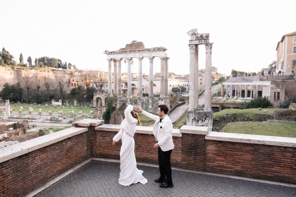 Bride and groom dancing during an elopement in Rome with Roman Forum ruins in the background, captured by an elopement photographer in Italy