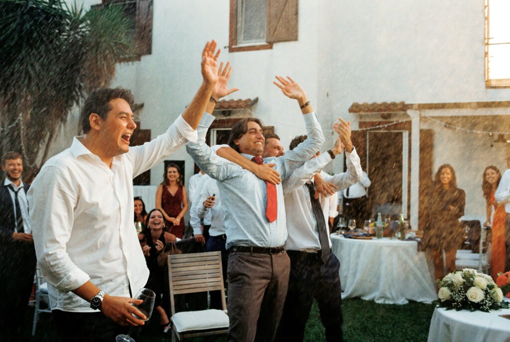 Guests celebrating and spraying champagne during an Italian wedding party photographed on 35mm film