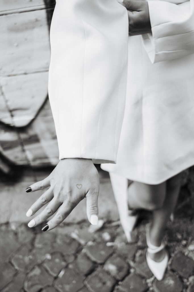 Black and white close up photo of bridal hand details and modern white dress during a pre wedding photoshoot in Rome, Italy.