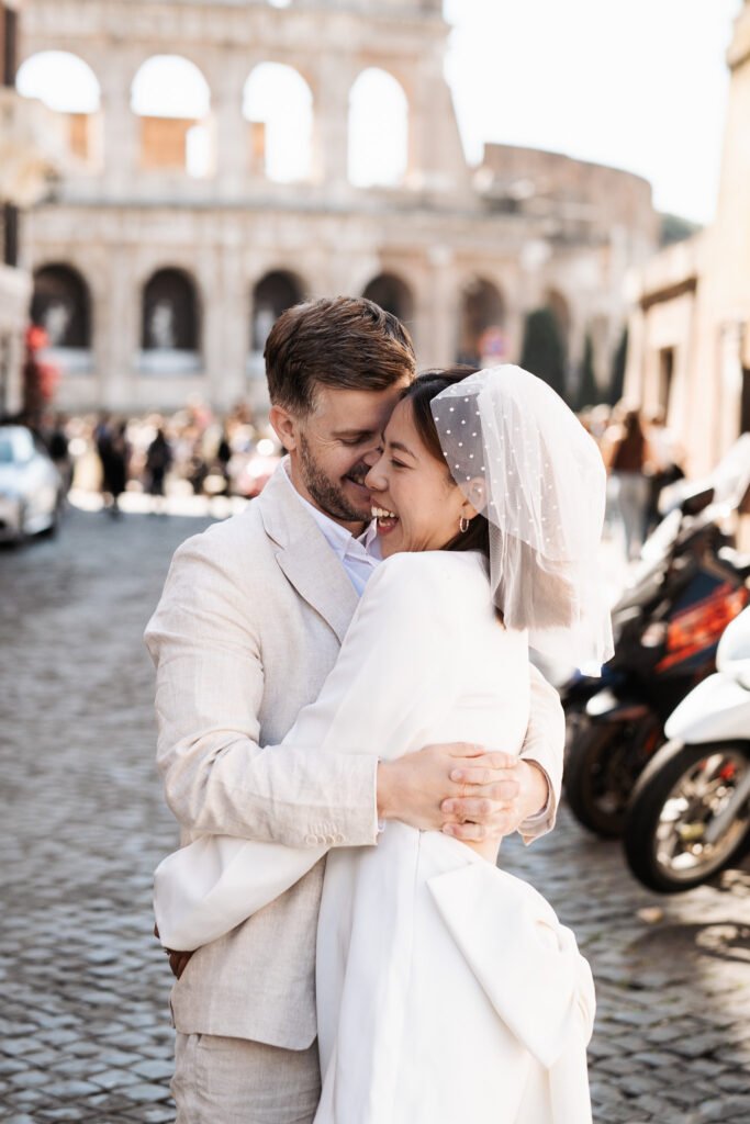 Romantic pre wedding portrait near the Colosseum in Rome featuring Vivian and Hamish embracing during their couple photoshoot in Italy.