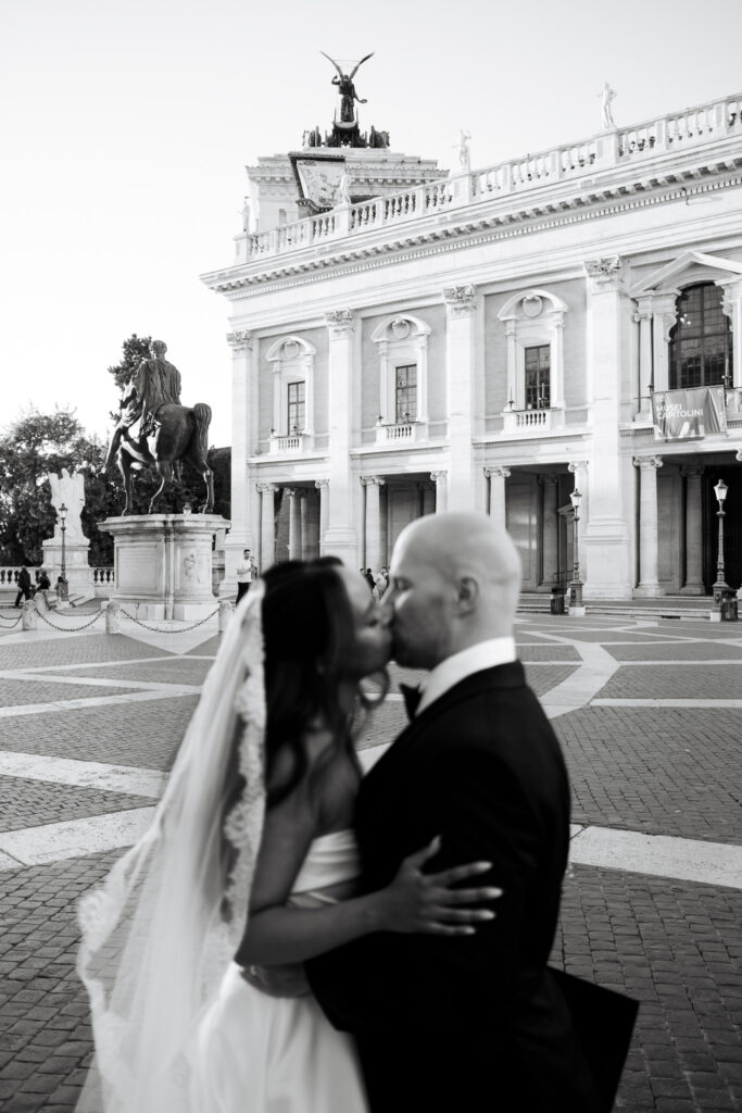 Bride and groom kissing in black and white at Capitoline Hill in Rome after their micro wedding ceremony.