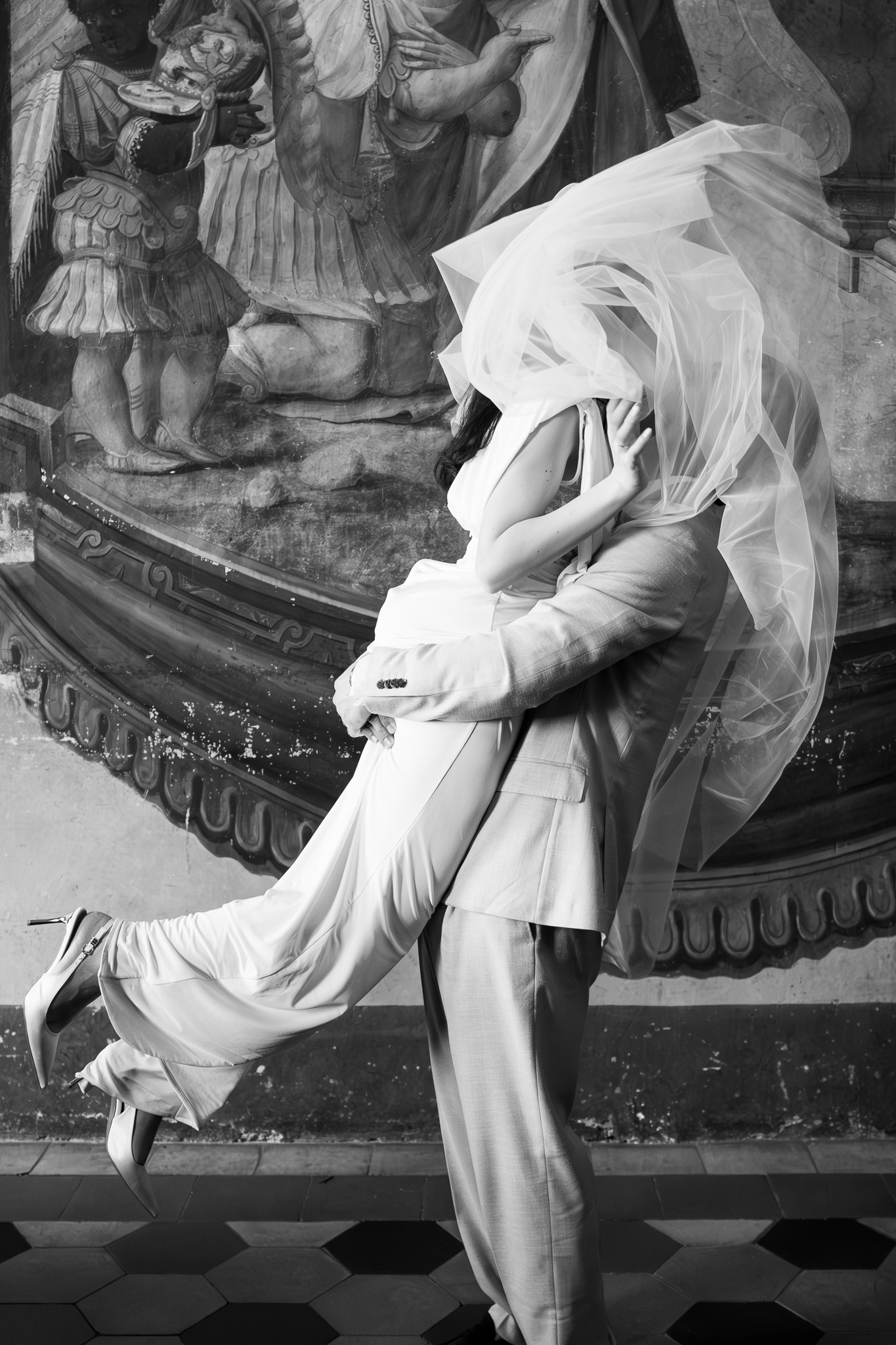 Sposi che si baciano sotto il velo all’interno del Comune di Tivoli durante un matrimonio civile, fotografati da un fotografo matrimonio Tivoli.