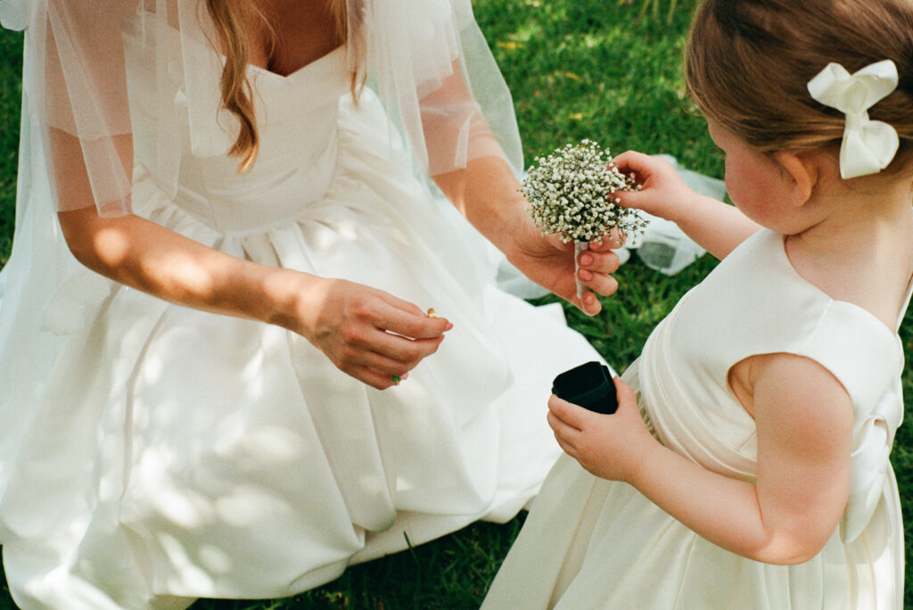 Child handing flowers to the bride during an intimate film wedding in Cefalù Sicily