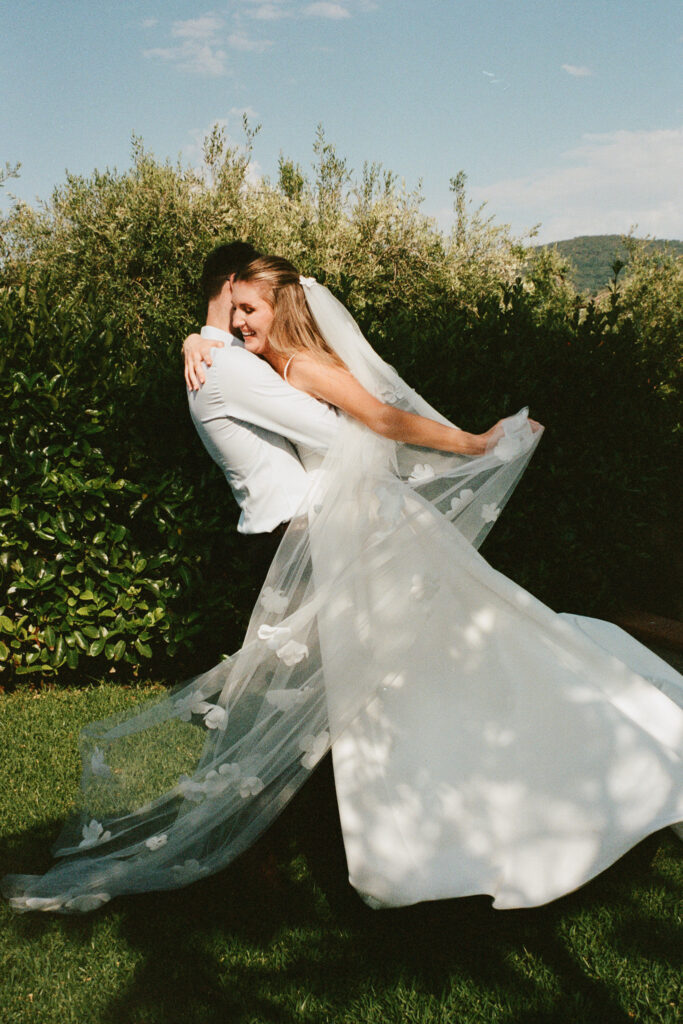 Bride and groom embracing in a villa garden during their Cefalù wedding on film
