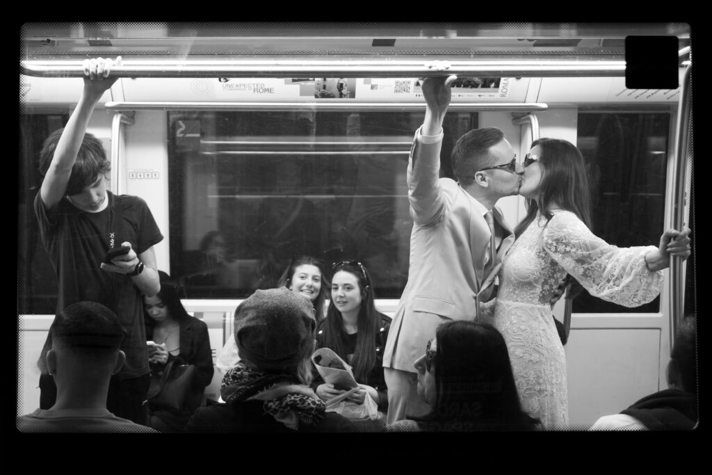 Bride and groom kissing inside a Rome metro train during their candid wedding photoshoot.