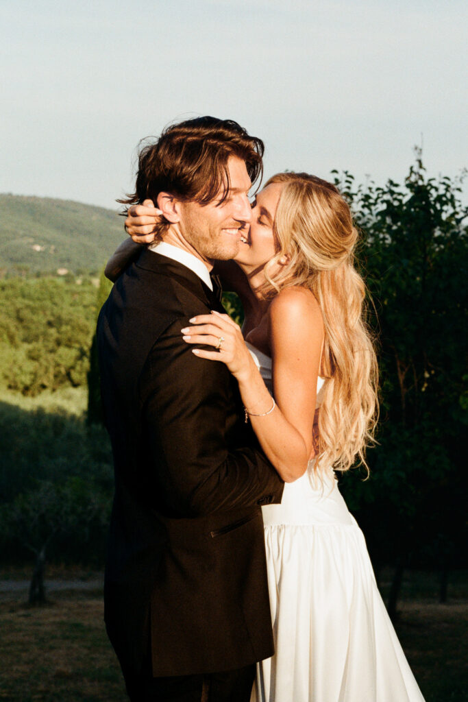 Jessica kissing Matthew during their wedding portraits in the Tuscan countryside