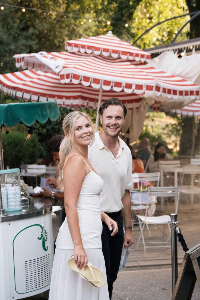 Riley and Maddie smiling together at a cafe in Villa Borghese during their Rome couple photoshoot