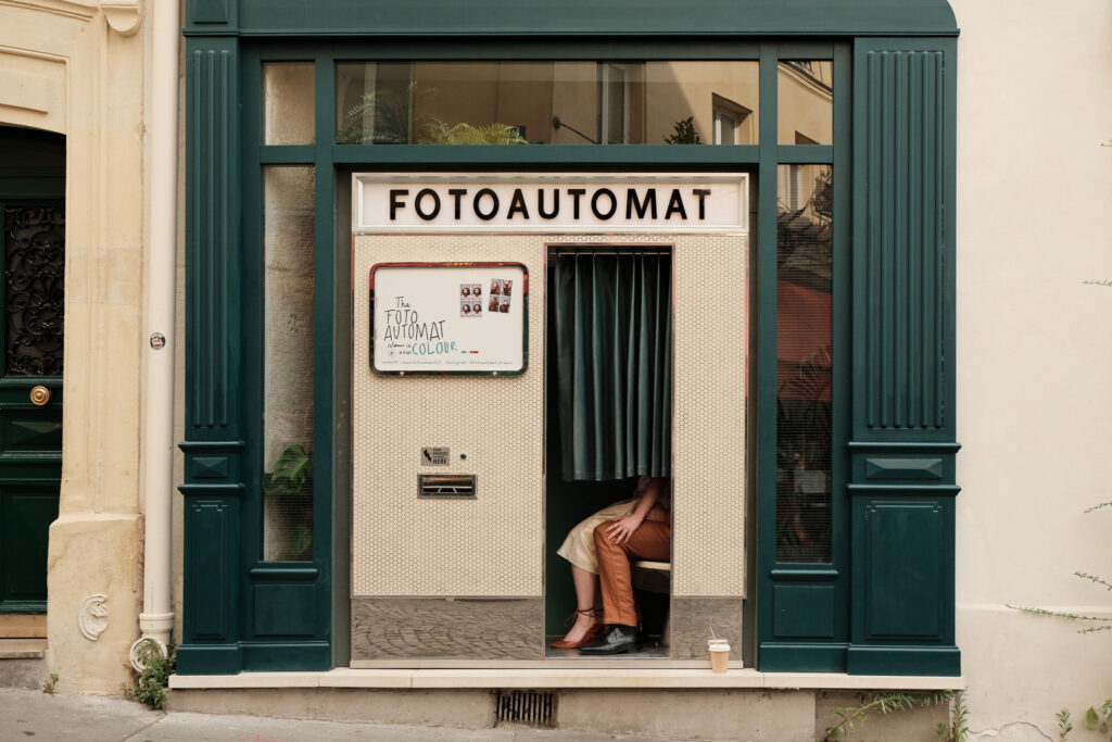 Kaylyn e Rynhardt insieme dentro il FotoAutomat durante il loro servizio fotografico di coppia a Montmartre, Parigi.