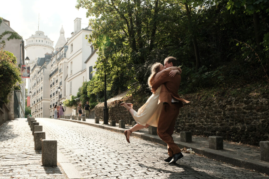 Kaylyn and Ryanhardt embracing on a cobblestone street during their morning couple photoshoot in Montmartre, Paris.