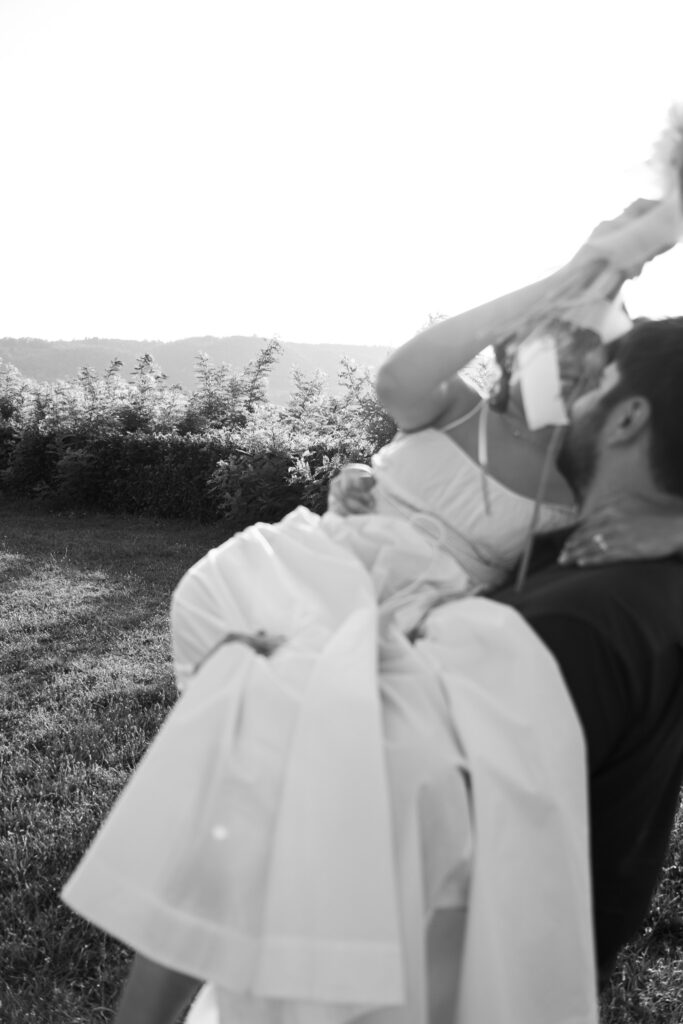 Groom lifting and kissing the bride in the Tuscan countryside during their intimate Val d’Orcia elopement.
